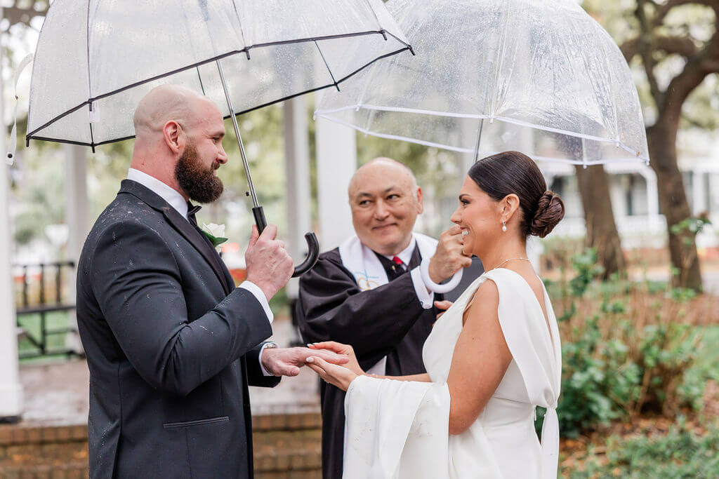 Couple elopes in Whitefield Square in Savannah, GA with clear umbrellas
