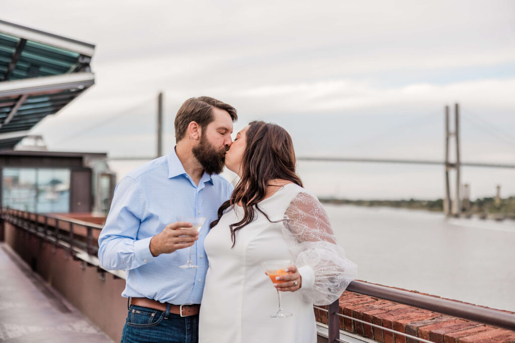 Couple kisses on a rooftop overlooking Savannah River