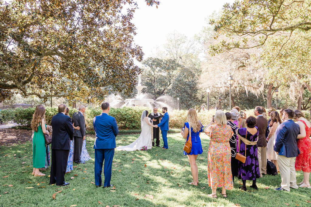 couple gets married in the grass by Forsyth Fountain